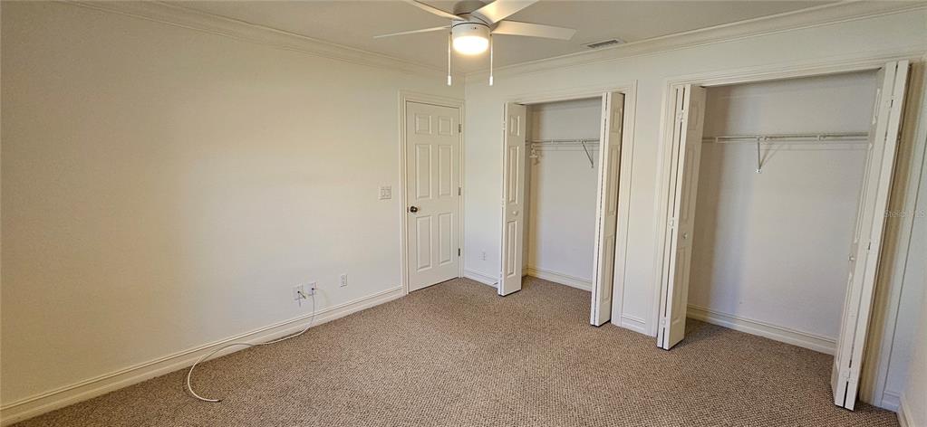 11729 Timberline Circle Fort Myers, FL 33966 - Photo 17 of 33 an empty room with closet and a ceiling fan