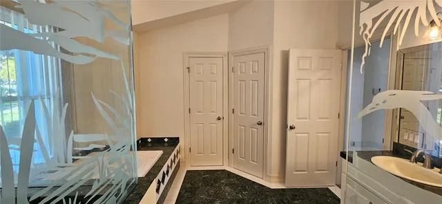 a bathroom with a tub sink and mirror