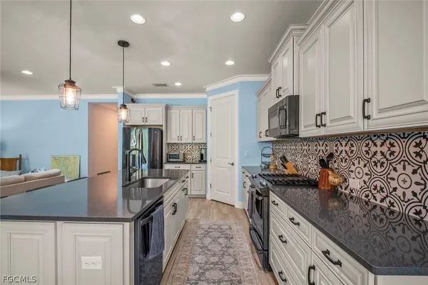 a kitchen with stainless steel appliances granite countertop a sink a stove and a refrigerator