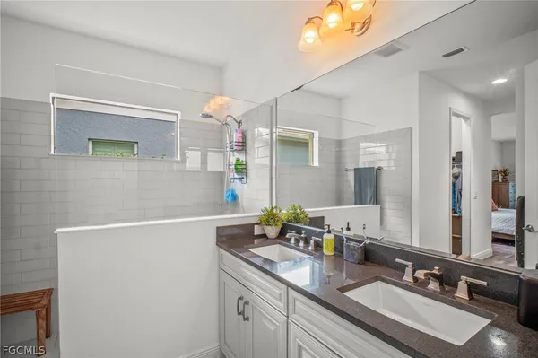 a bathroom with a sink double vanity granite and a mirror