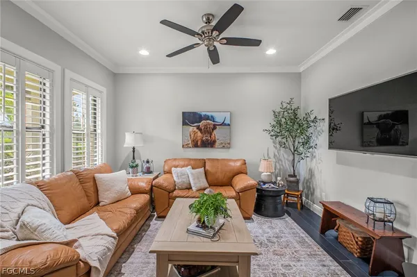 a living room with furniture a flat screen tv and a large window