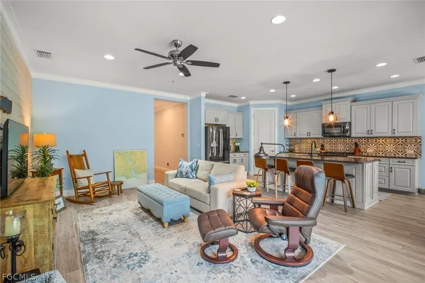 a living room with furniture a flat screen tv and kitchen view