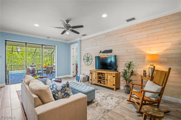 a living room with furniture a flat screen tv and a large window