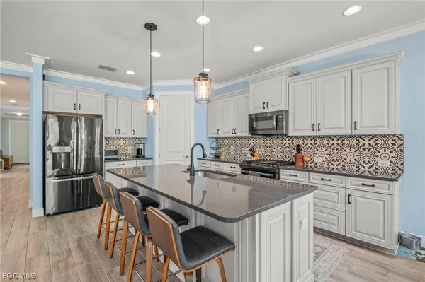 a kitchen with a sink a microwave a refrigerator and cabinets