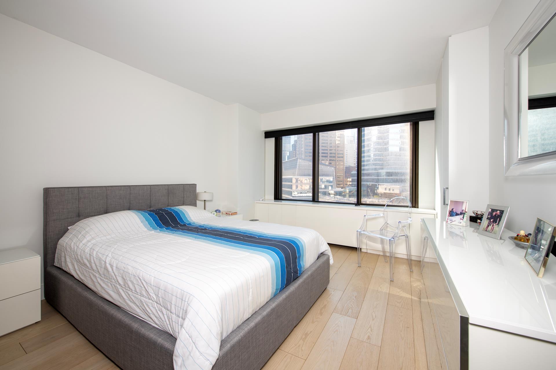 200 East 61st Street, Unit 14B Manhattan, NY 10065 - Photo 4 of 15 a bedroom with a bed and a large window