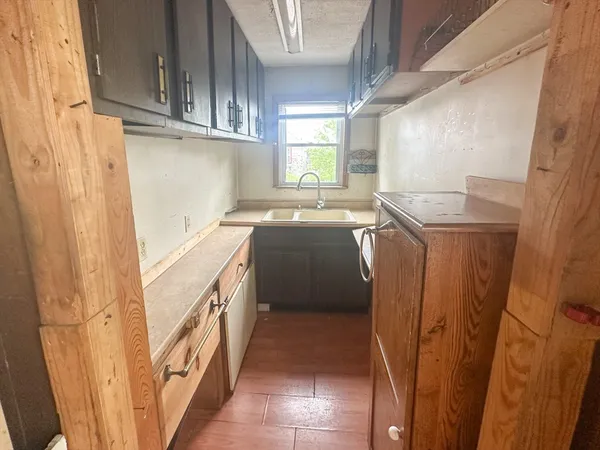 a kitchen with a sink a stove top oven and cabinets