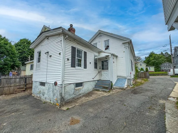 a view of a house with a yard and wooden fence