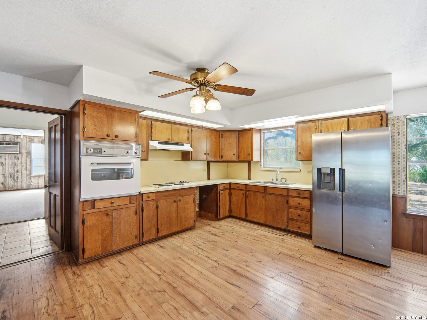 300 Ave M Hondo, TX 78861 - Photo 15 of 37 a large kitchen with stainless steel appliances granite countertop a refrigerator a sink dishwasher a stove and a dining table with wooden floor