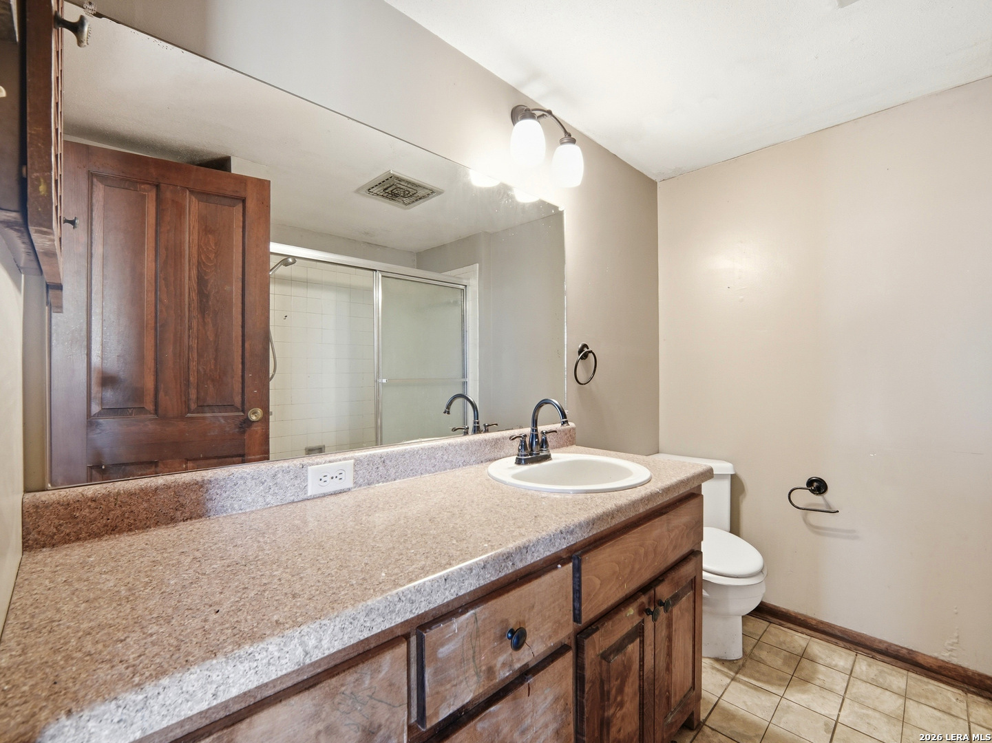 300 Ave M Hondo, TX 78861 - Photo 27 of 37 a bathroom with a granite countertop sink a toilet and a mirror