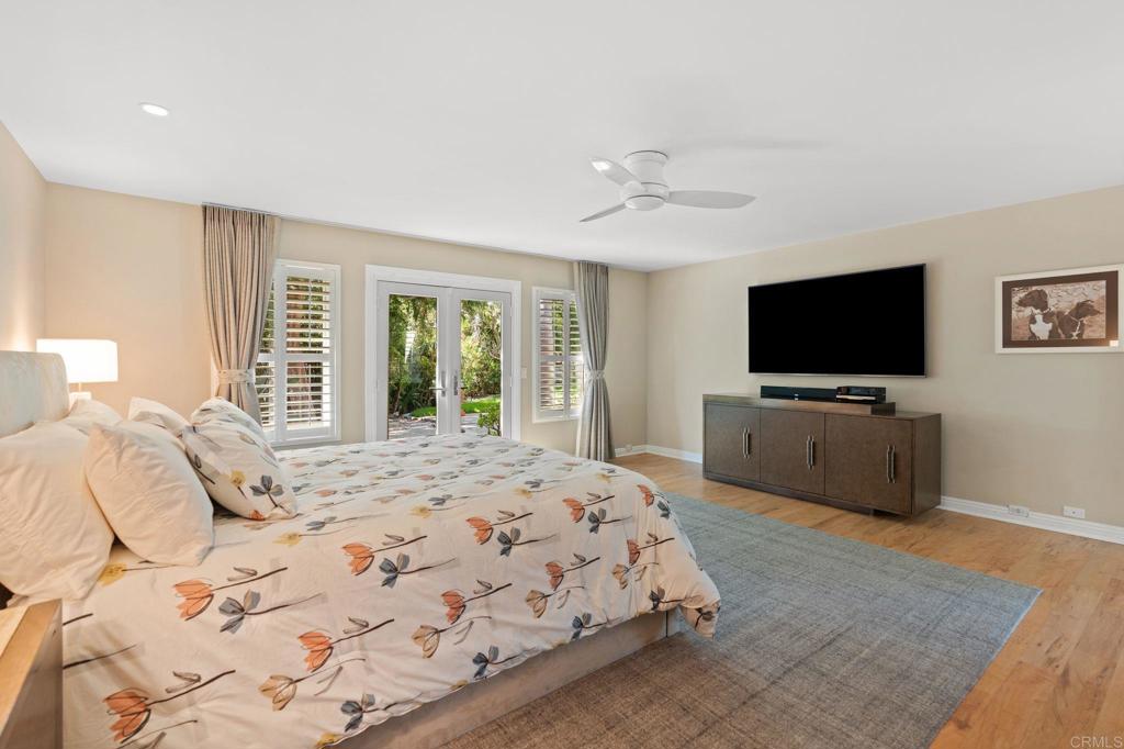1229 Caminito Graciela Encinitas, CA 92024 - Photo 17 of 34 a bedroom with a large bed and a flat screen tv
