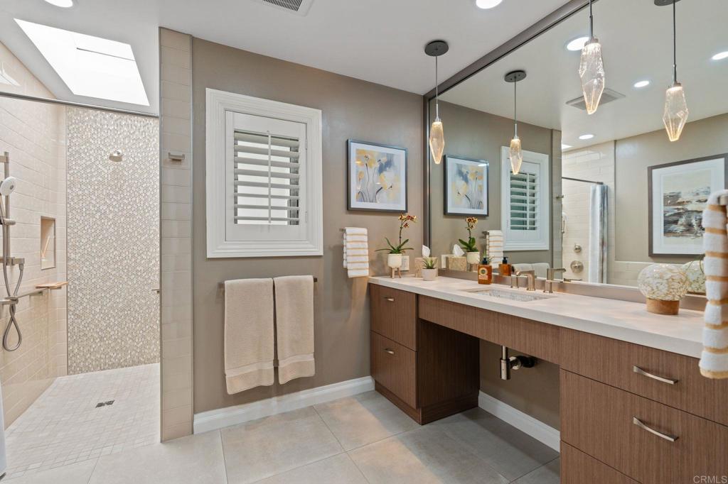 1229 Caminito Graciela Encinitas, CA 92024 - Photo 22 of 34 a spacious bathroom with a double vanity sink a large mirror and a shower