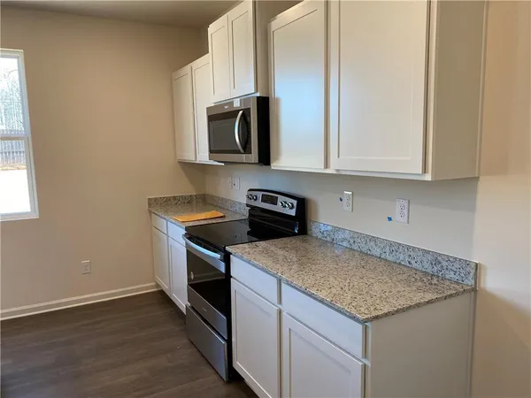 a kitchen with stainless steel appliances granite countertop a sink and a microwave