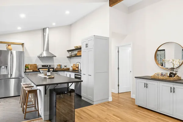 a kitchen with refrigerator a table and chairs