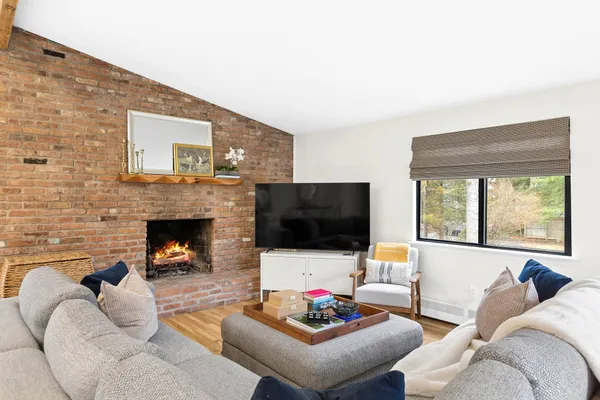 a living room with furniture a fireplace and a flat screen tv