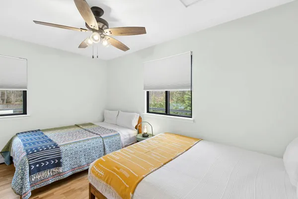 a bedroom with two beds and ceiling fan