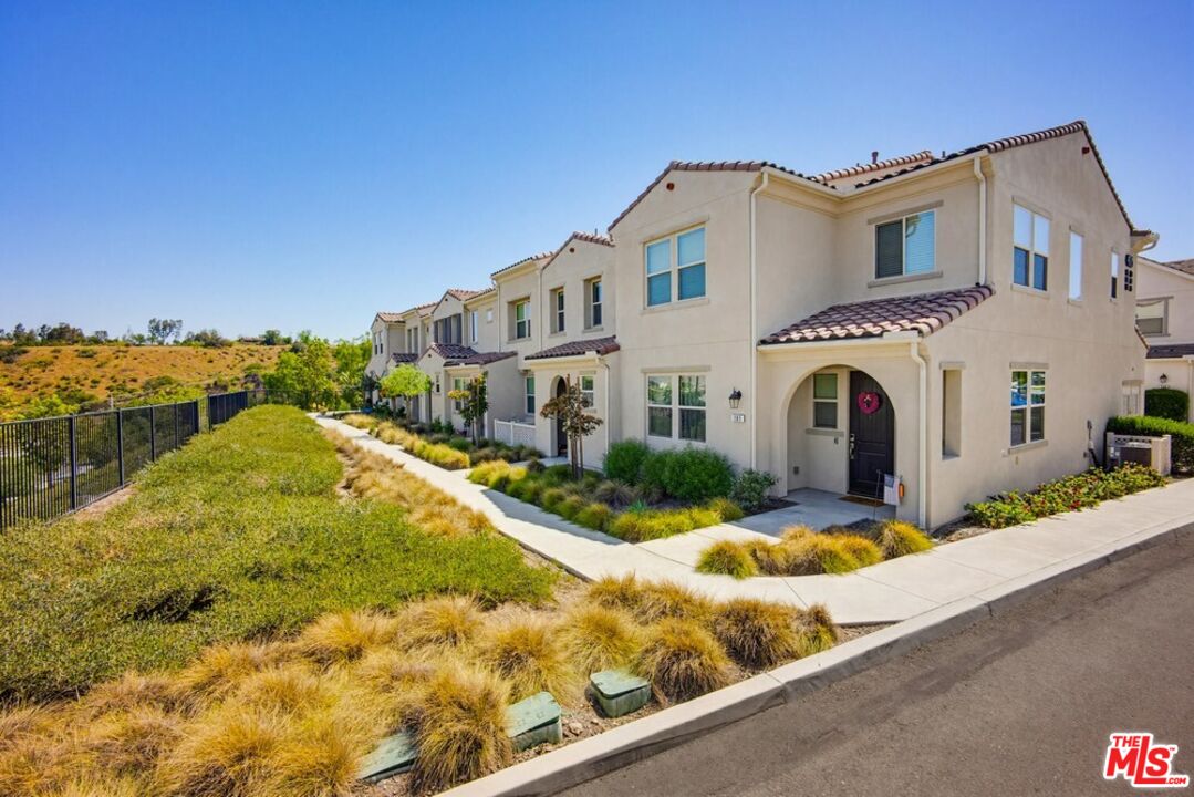 4105 Cameron Way, Unit 103 Corona, CA 92883 - Photo 2 of 30 a view of a white house with a yard and potted plants