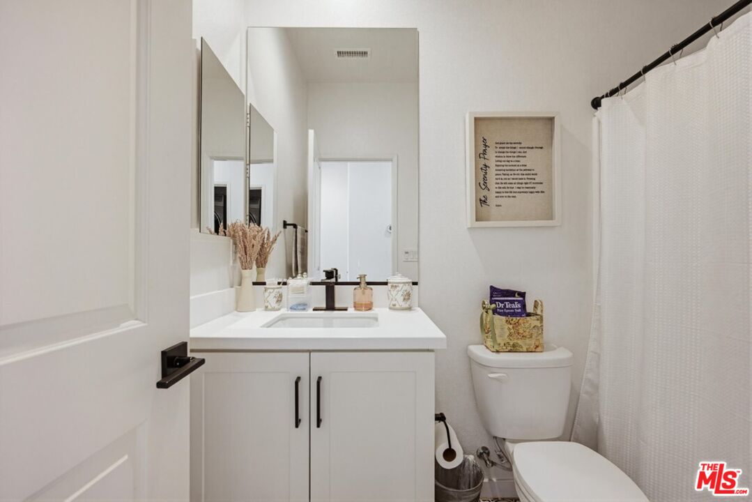 4105 Cameron Way, Unit 103 Corona, CA 92883 - Photo 22 of 30 a bathroom with a toilet sink and mirror
