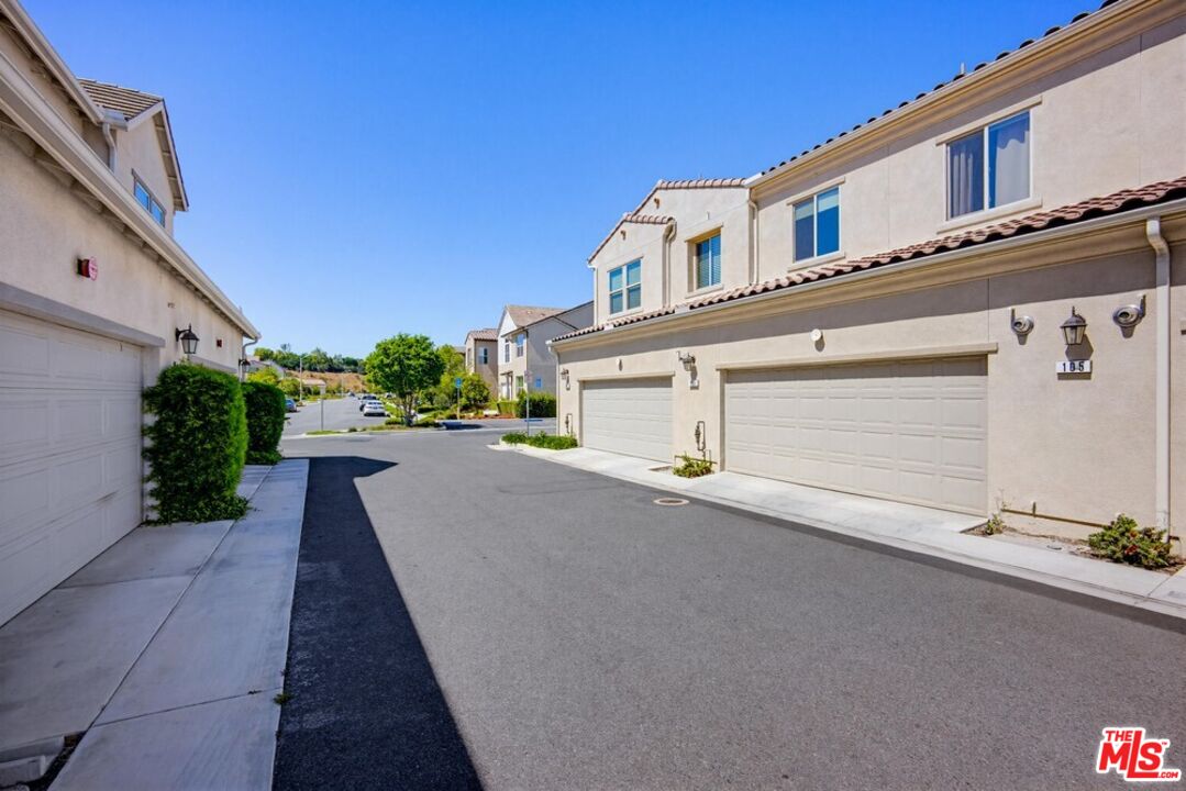 4105 Cameron Way, Unit 103 Corona, CA 92883 - Photo 28 of 30 a front view of a house with a yard and a garage