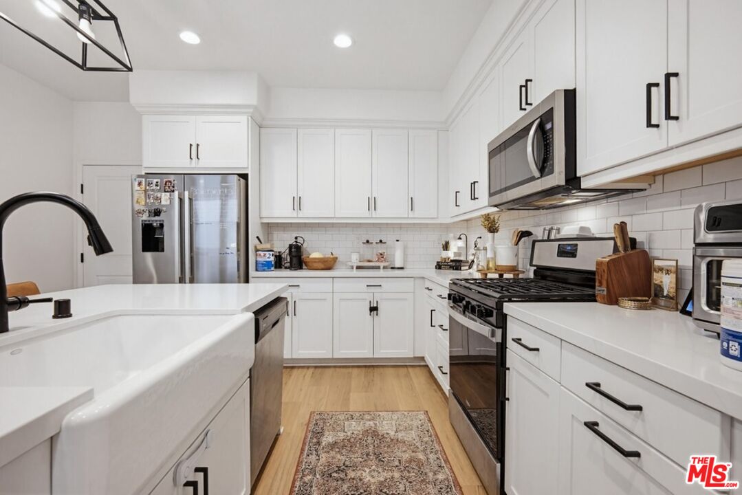 4105 Cameron Way, Unit 103 Corona, CA 92883 - Photo 9 of 30 a kitchen with stainless steel appliances granite countertop a refrigerator and a stove top oven