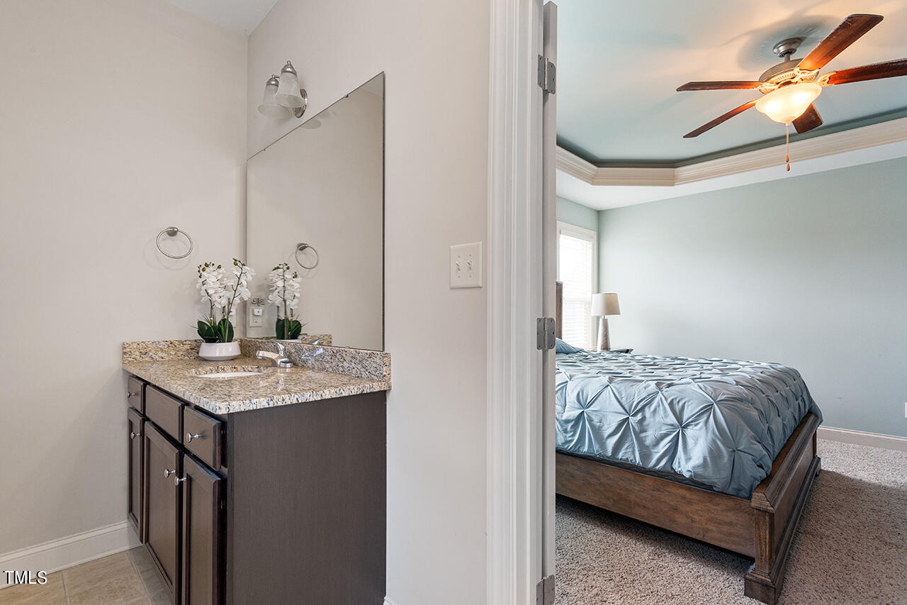 116 Celestial Drive Garner, NC 27529 - Photo 13 of 23 a bedroom with a bed and a chandelier