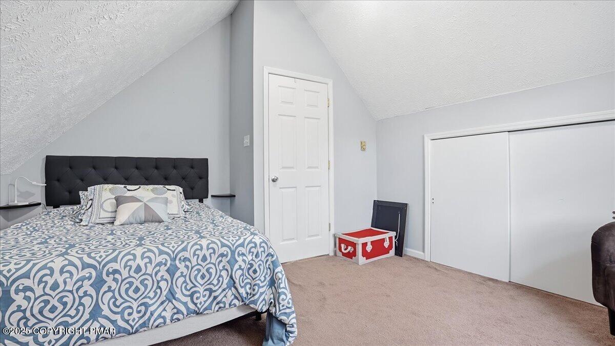 109 Saunders Drive Bushkill, PA 18324 - Photo 22 of 106 a bedroom with a bed and a lamp