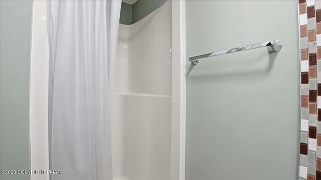 a view of a wooden house with large trees and wooden fence