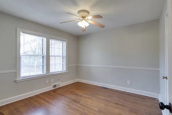 an empty room with wooden floor and window