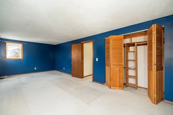 an empty room with closet and wooden door