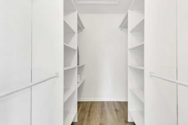 a view of walk in closet with wooden floor