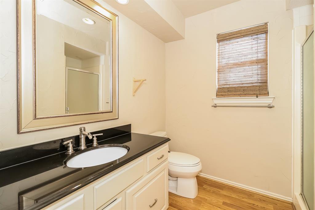 6308 Winton Street Dallas, TX 75214 - Photo 14 of 17 a bathroom with a granite countertop sink toilet and mirror