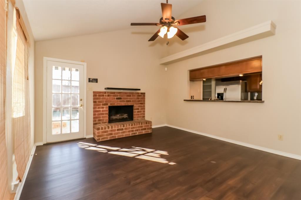 6308 Winton Street Dallas, TX 75214 - Photo 6 of 17 a view of a livingroom with a fireplace a ceiling fan and wooden floor