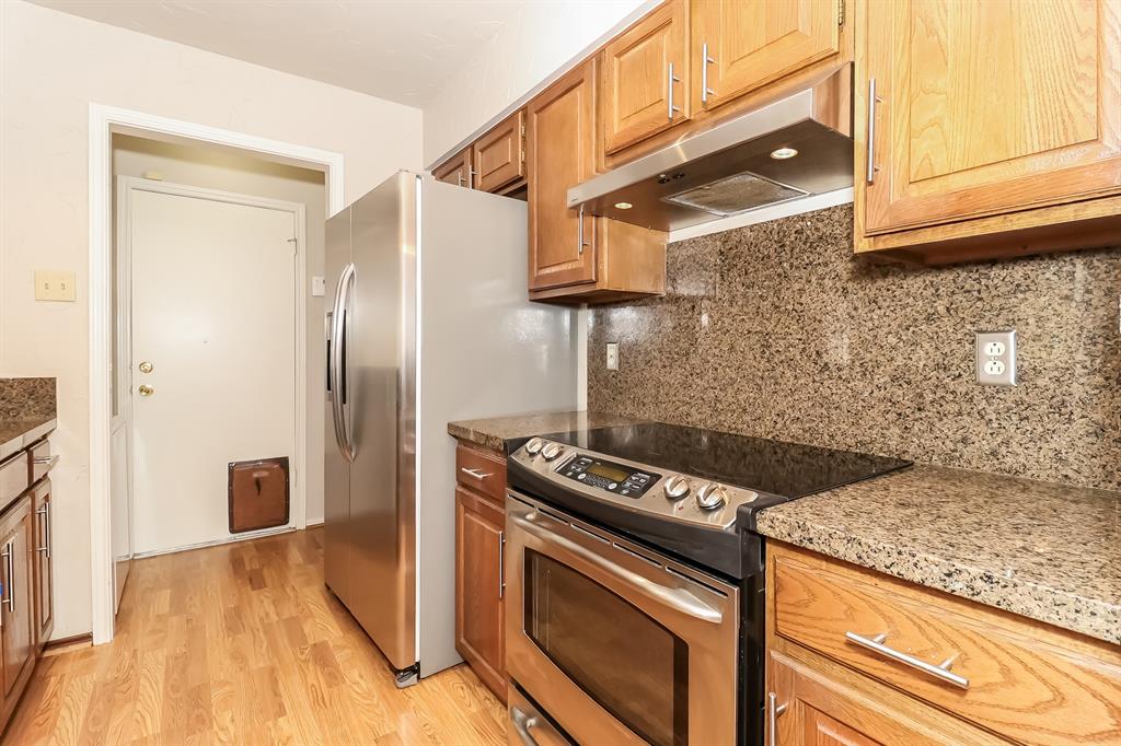 6308 Winton Street Dallas, TX 75214 - Photo 9 of 17 a kitchen with granite countertop a stove and a refrigerator