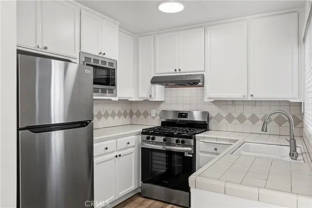 a kitchen with stainless steel appliances a refrigerator sink and cabinets