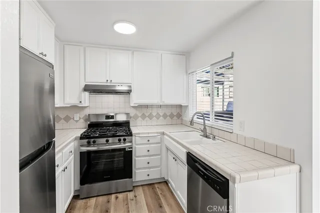 a kitchen with cabinets appliances and a window