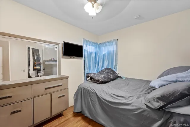 a bedroom with a bed and a large mirror on the dresser