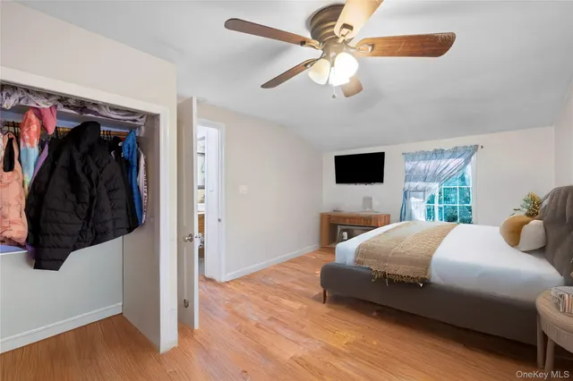 a bedroom with a bed and a flat tv screen on dresser