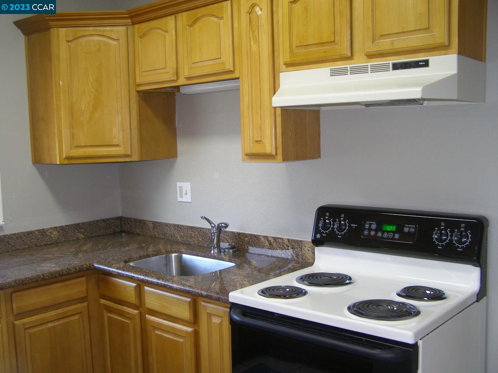 1128 16th Street Oakland, CA 94607 - Photo 14 of 26 a kitchen with a sink a stove and cabinets