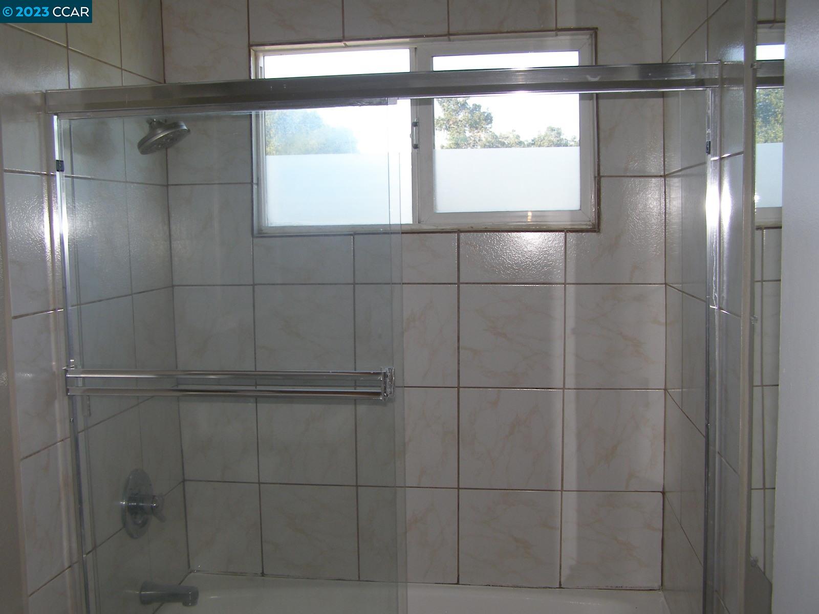 1128 16th Street Oakland, CA 94607 - Photo 20 of 26 a bathroom with a glass shower door