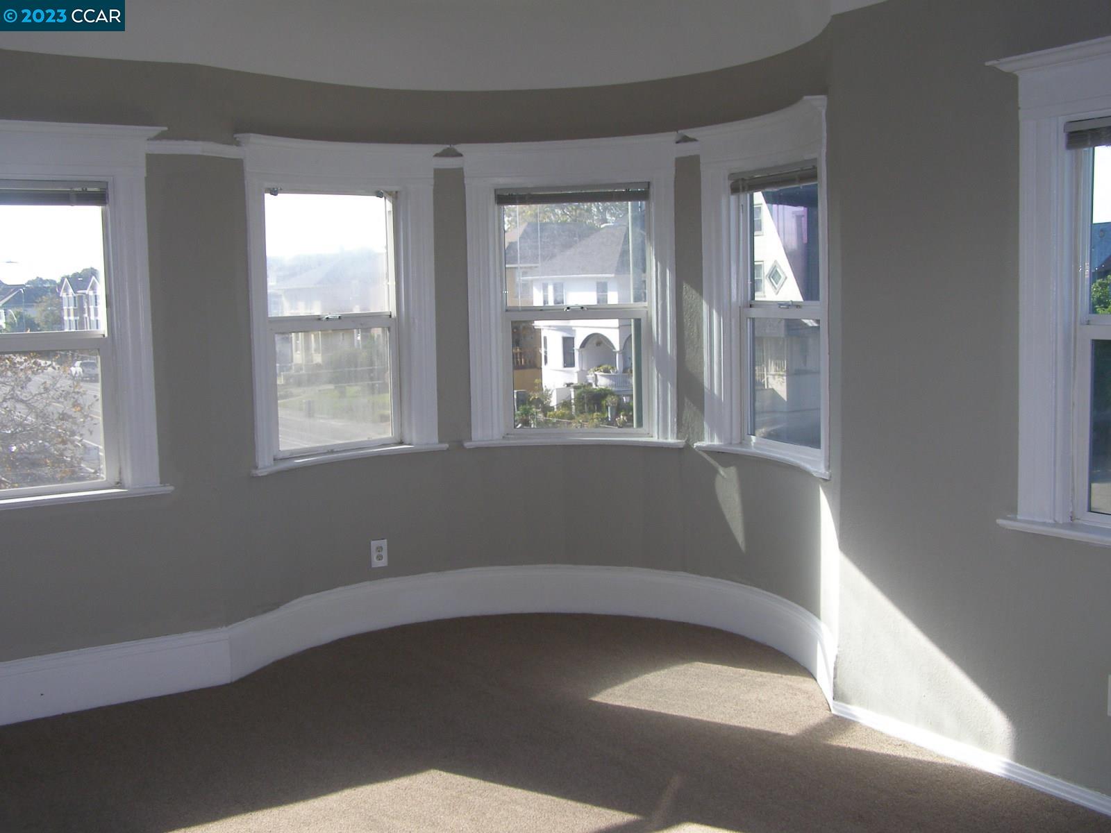 1128 16th Street Oakland, CA 94607 - Photo 6 of 26 a view of empty room with wooden floor and fan