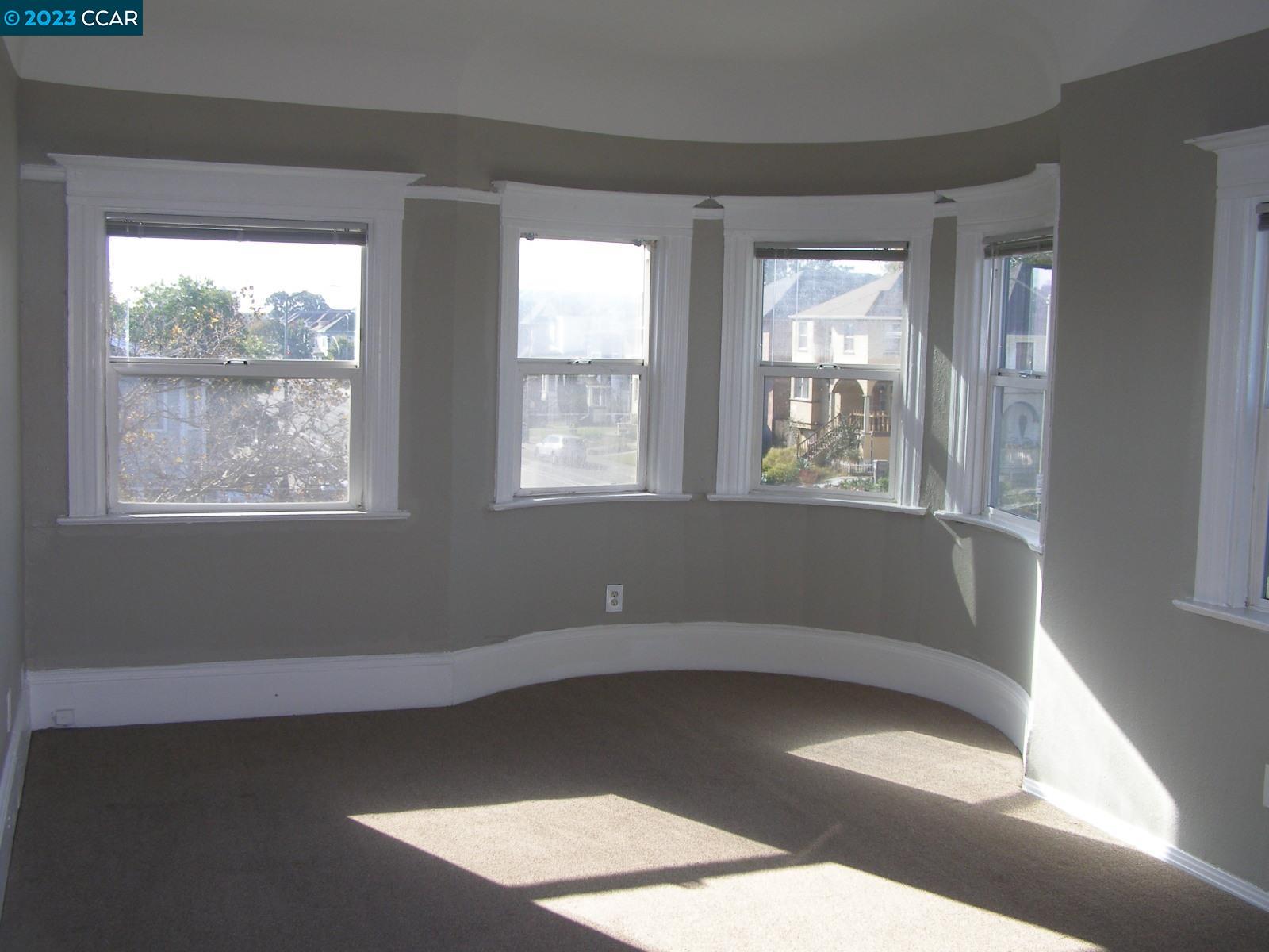 1128 16th Street Oakland, CA 94607 - Photo 7 of 26 a view of an empty room with wooden floor and a window