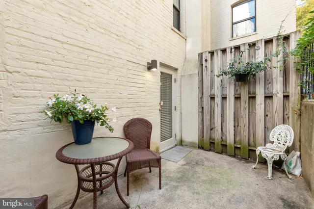 a backyard with table and chairs potted plants