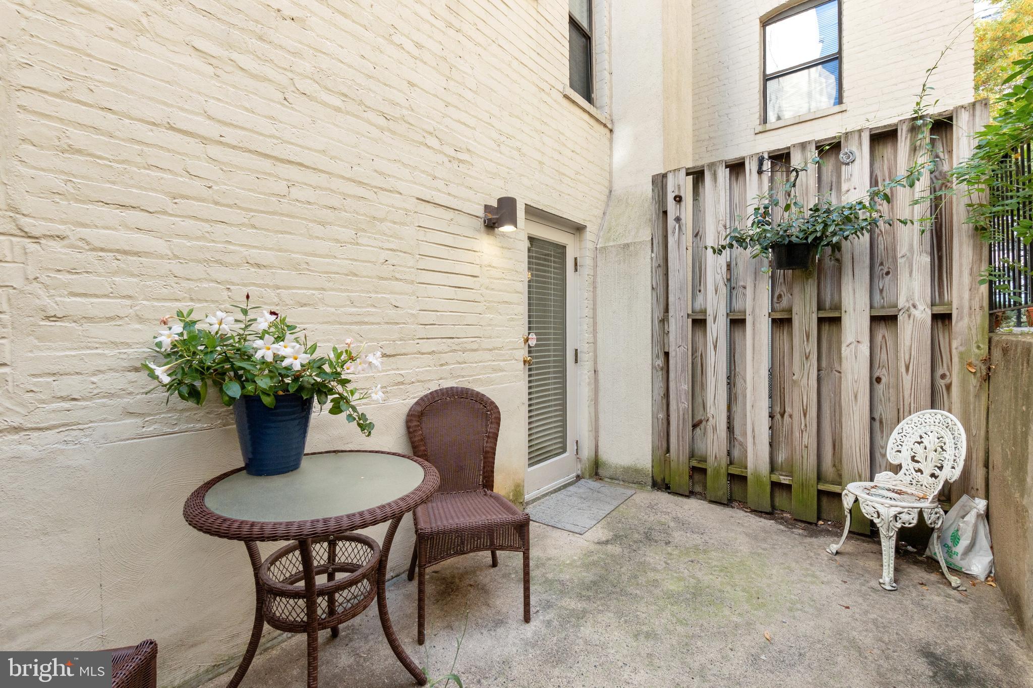 2145 California Street Northwest, Unit 102 Washington, DC 20008 - Photo 19 of 21 a backyard with table and chairs potted plants