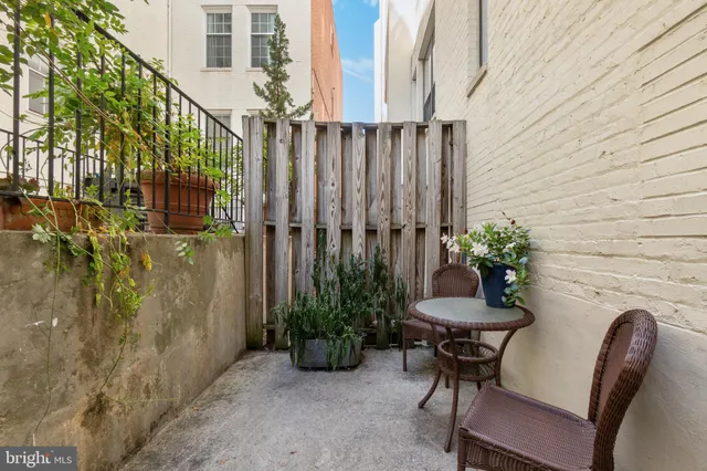 a porch with a table and chairs and potted plants