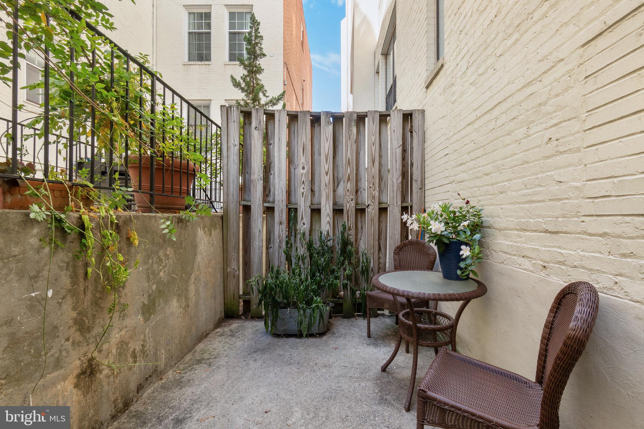 2145 California Street Northwest, Unit 102 Washington, DC 20008 - Photo 20 of 21 a porch with a table and chairs and potted plants