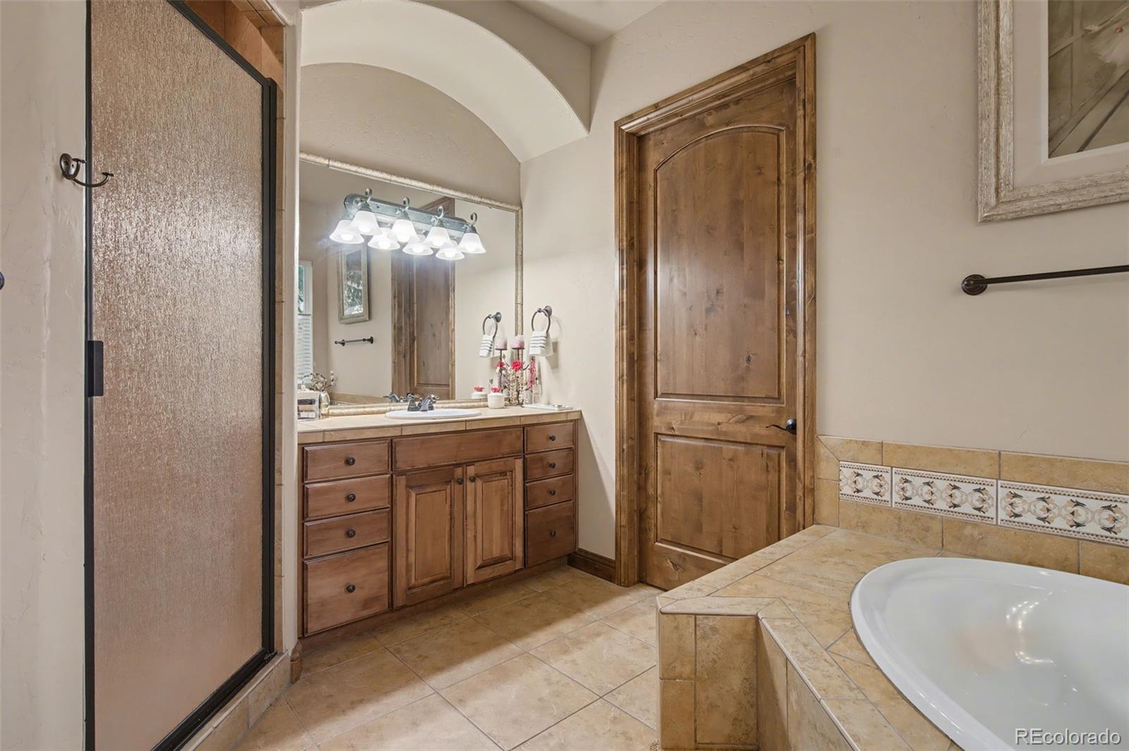 870 Mont Blanc View Colorado Springs, CO 80906 - Photo 20 of 42 a spacious bathroom with a granite countertop sink mirror and a bathtub