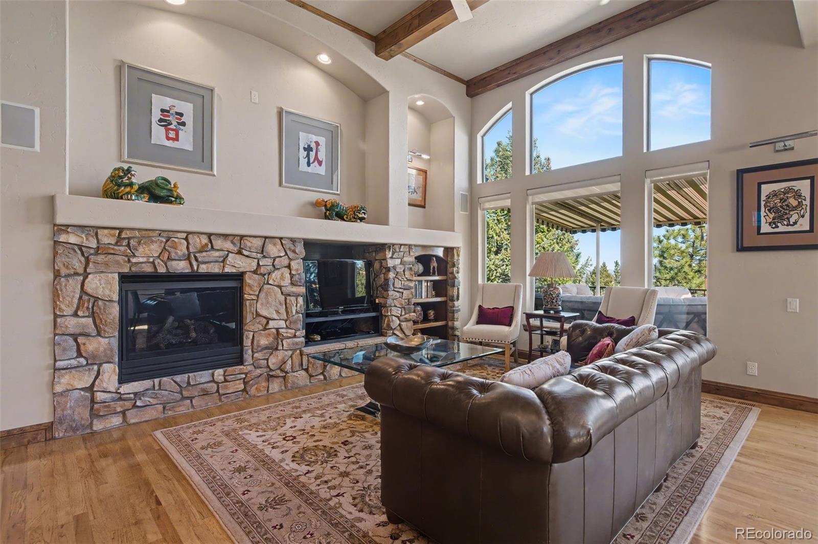 870 Mont Blanc View Colorado Springs, CO 80906 - Photo 7 of 42 a living room with furniture a large window and a fireplace