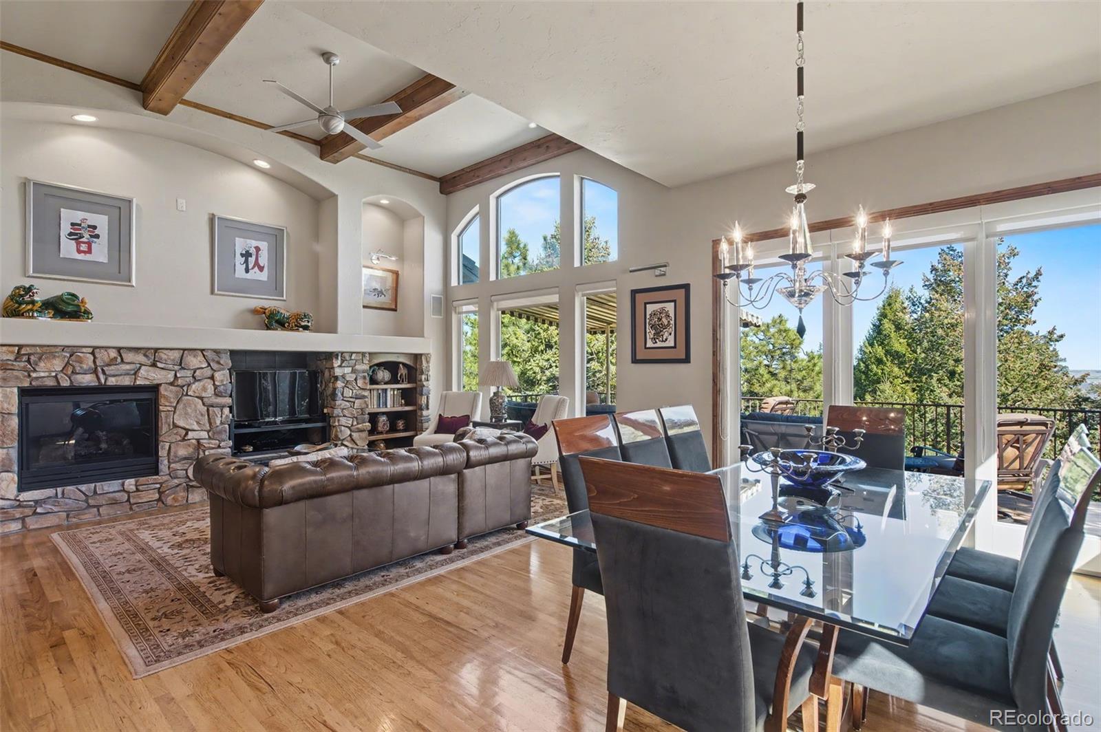 870 Mont Blanc View Colorado Springs, CO 80906 - Photo 9 of 42 a living room with furniture a fireplace and a chandelier