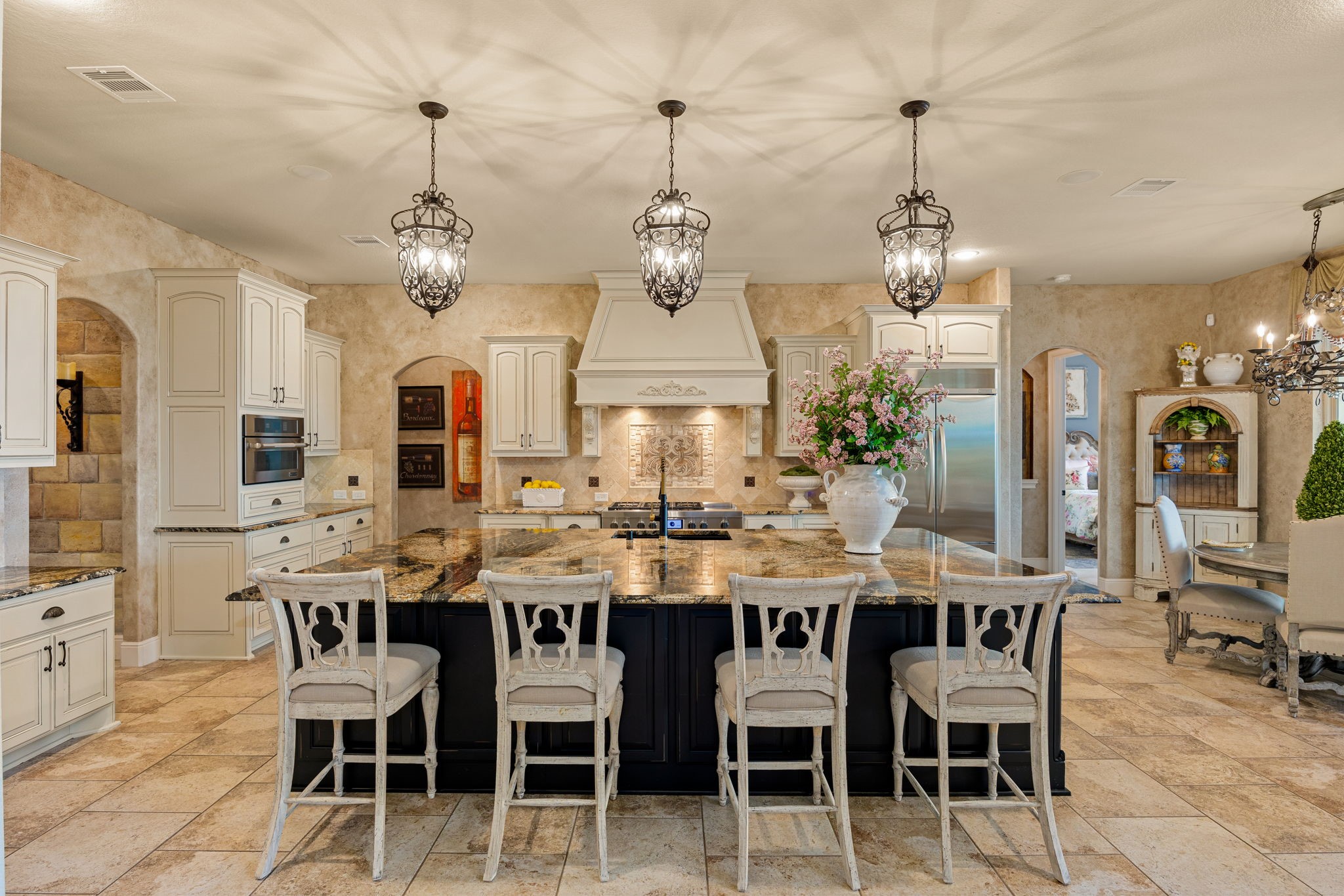 26515 Ashley Ridge Lane Katy, TX 77494 - Photo 13 of 50 Elegant kitchen with a spacious island, ornate lighting fixtures, and a breakfast dining space. Features high-end appliances, custom cabinetry, and a warm, inviting atmosphere. Perfect for entertaining and family gatherings.