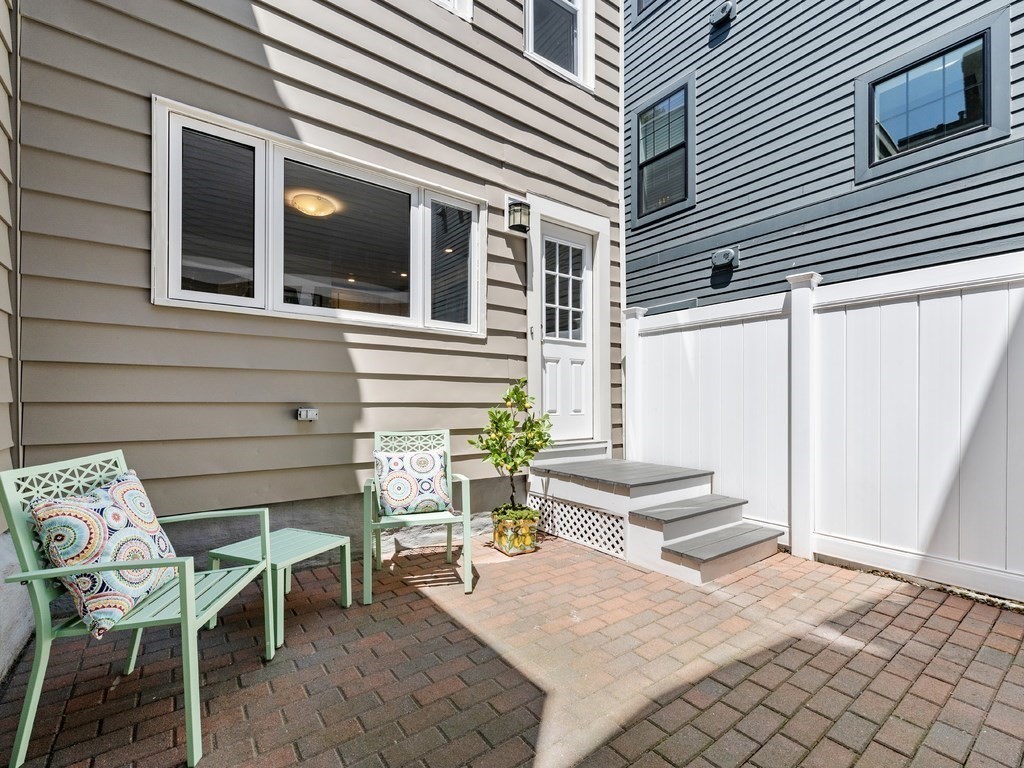 18 R Polk Street Boston, MA 02129 - Photo 3 of 19 a view of a patio with table and chairs and wooden fence