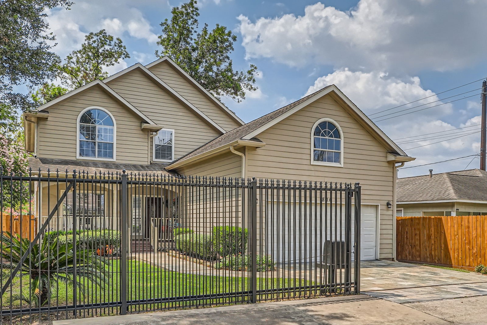 806 East 29th Street Houston, TX 77009 - Photo 1 of 30 This two-story home features a charming exterior with arched windows and a gabled roof. It has a fenced yard for added security, landscaped greenery, and a two-car garage.